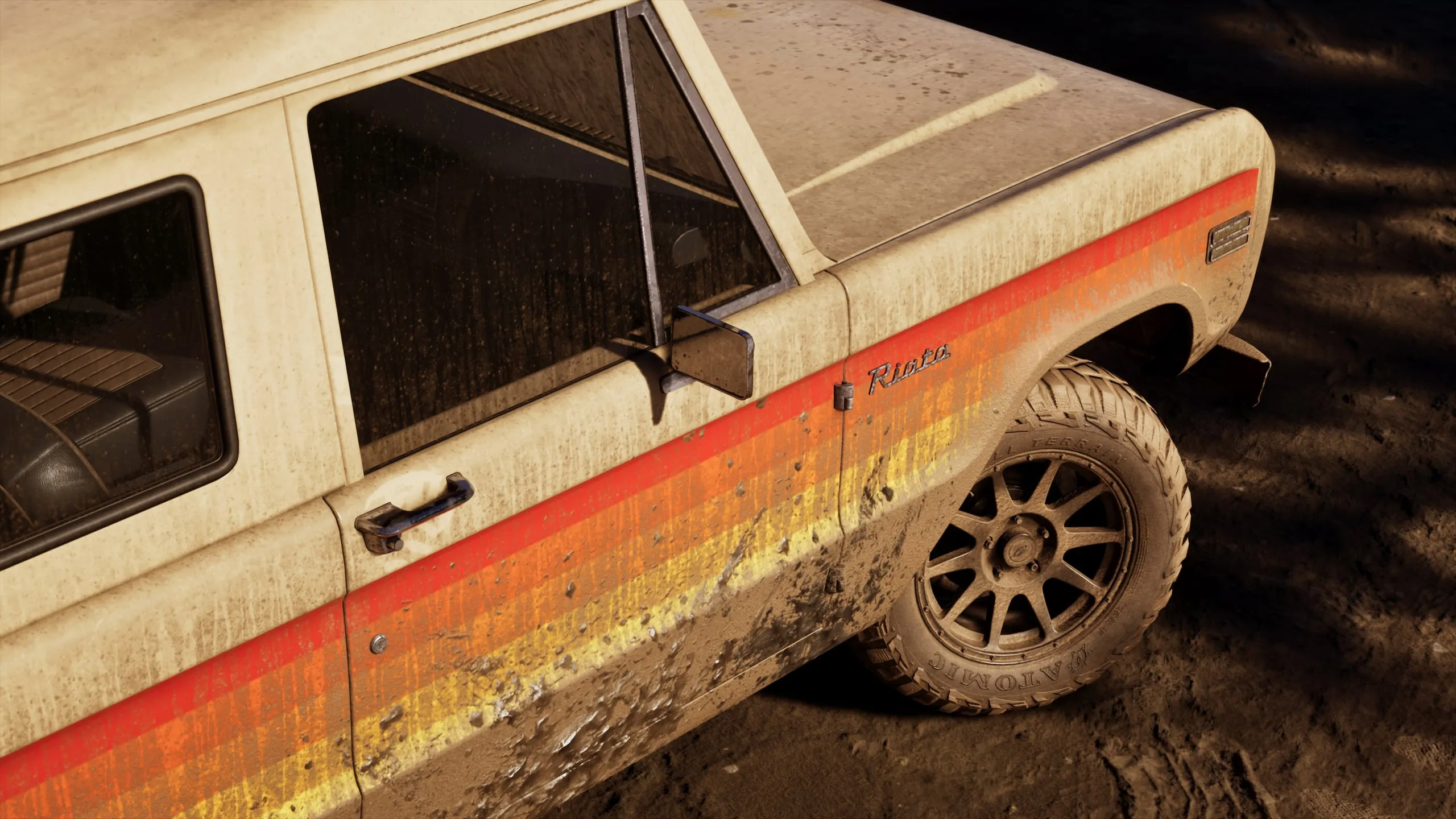 A beige Riata off-roader with sunset stripes, splattered in mud