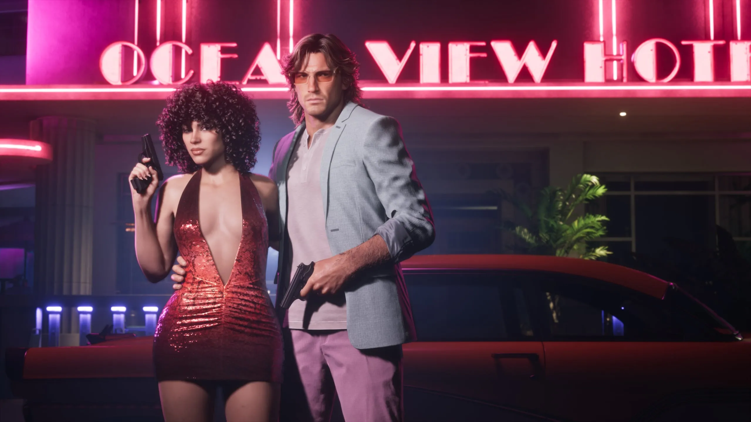 Jason and Lucia in retro outfits under the Ocean View Hotel neon